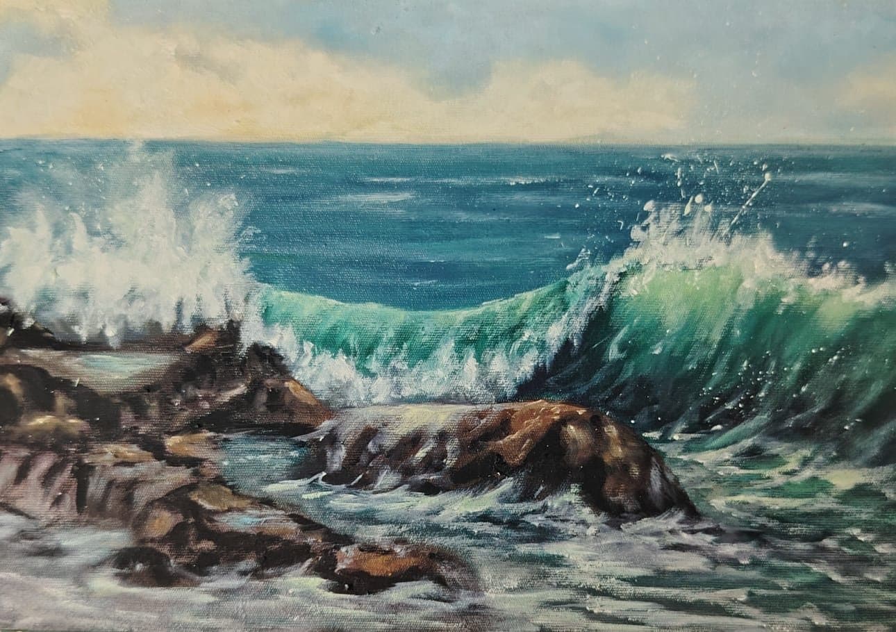 Green wave breaking over rocks