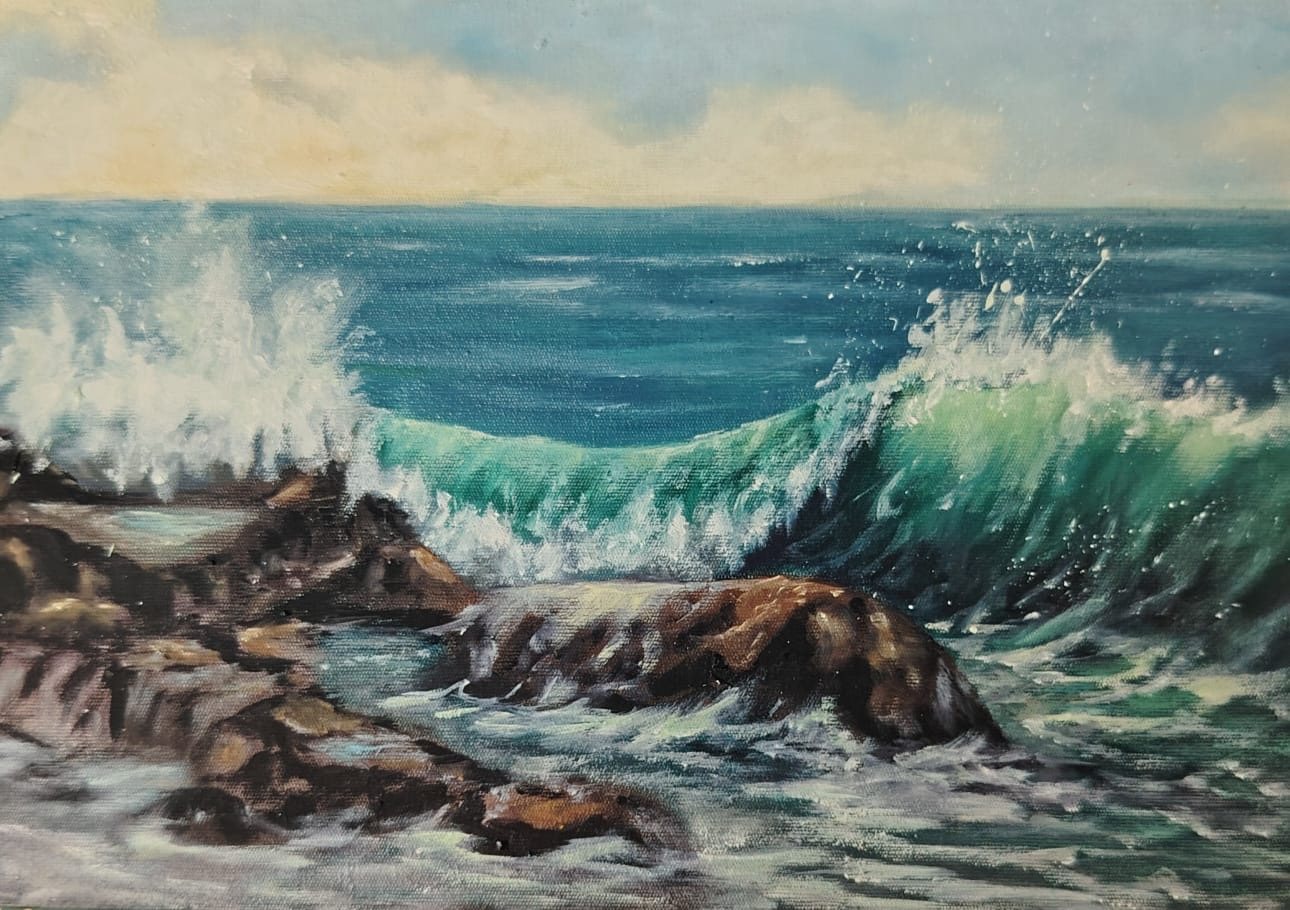 Green wave breaking over rocks