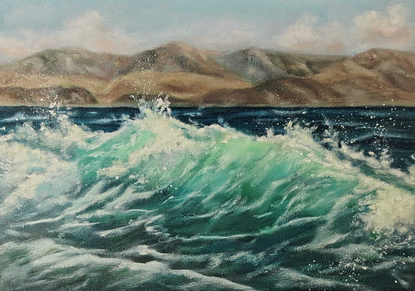 Turquoise wave with mountains behind